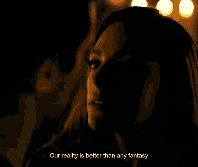 a woman in a dark room with the words " our reality is better than any fantasy " below her