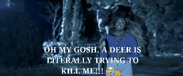 a woman in a blue shirt is being attacked by a deer in a dark forest
