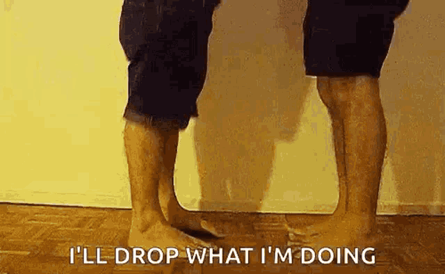 two men are standing next to each other on the floor .