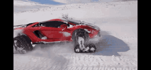 a red car is driving through the snow with the number 0 on the front