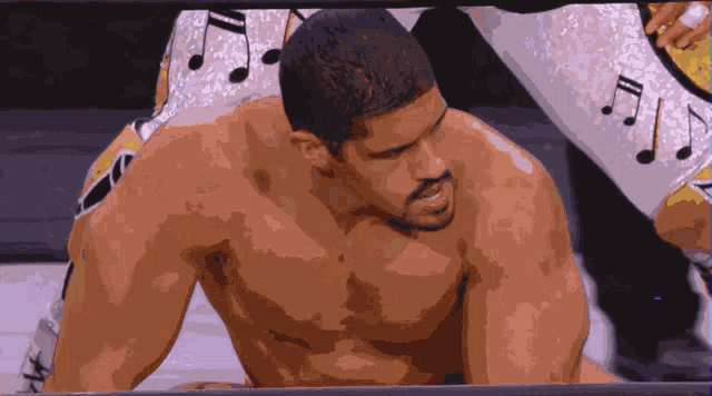 a shirtless wrestler in a wrestling ring with music notes on his shorts
