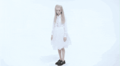 a woman in a white dress and black shoes is dancing in front of a white background