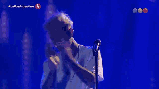 a man singing into a microphone with the words la voz argentina on the screen