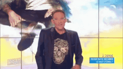 a man in a suit and a skull t-shirt is standing in front of a screen that says adivive