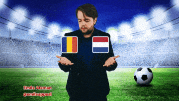 a man in a suit stands in front of a soccer field with a soccer ball and two flags