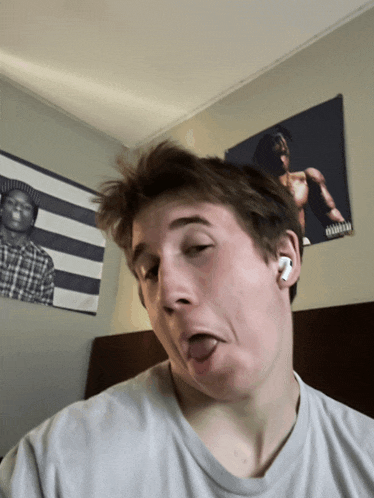 a young man making a funny face in front of a poster that says advisory