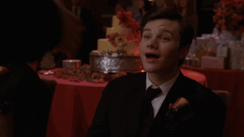 a man in a suit is dancing with a woman in a wheelchair