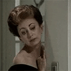 a woman is looking at herself in a mirror .
