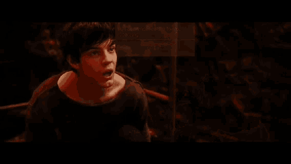 a man with gray hair and a red shirt is making a funny face in a movie .