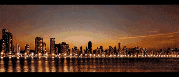 a city skyline with buildings lit up at night