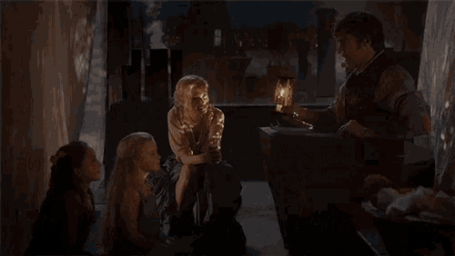 two little girls are standing next to each other in a dark room .
