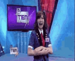 a woman is standing in front of a television screen that says ten