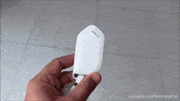 a person is holding a white key fob with the letters ks on it