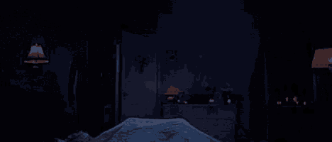 a person is laying on a bed in a dark room with a red light .