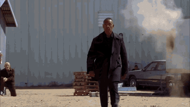 a man in a suit is walking in front of a building