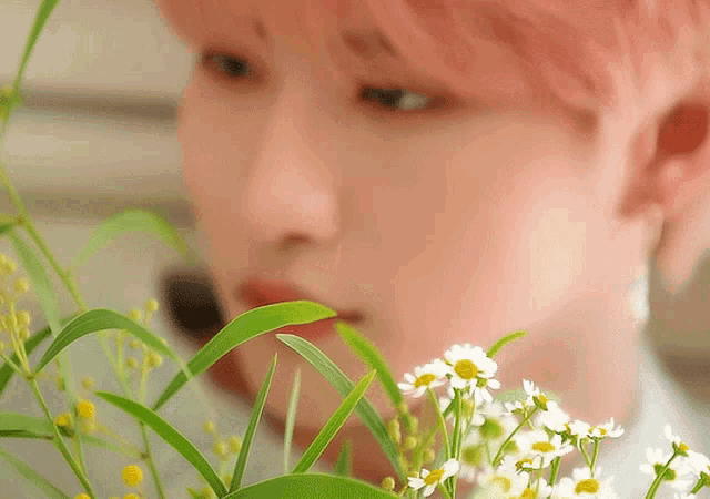 a close up of a person smelling a flower