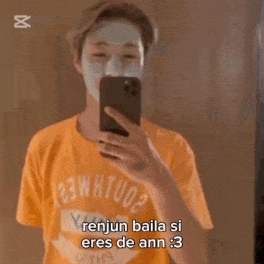 a man with a mask on his face is taking a picture of himself with his phone .