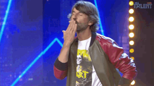 a man blows a kiss while wearing a shirt that says rt