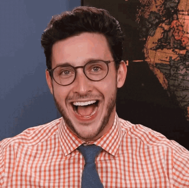 a man wearing glasses and a plaid shirt is making a funny face