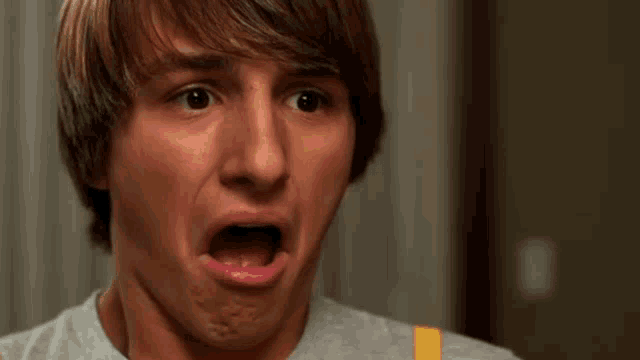 a young man is making a surprised face with his mouth wide open