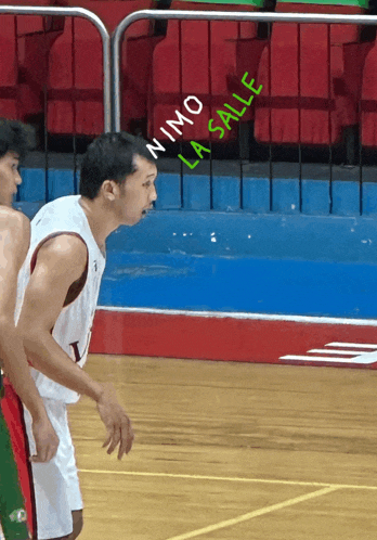 a man on a basketball court with the words " nino la salle " written on the floor