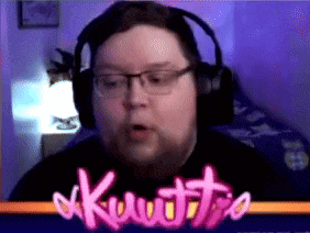 a man wearing headphones and glasses is behind a screen that says kuuttio