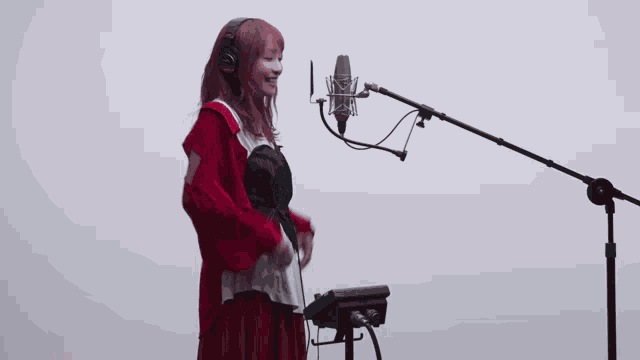 a woman with red hair is singing into a microphone while wearing headphones