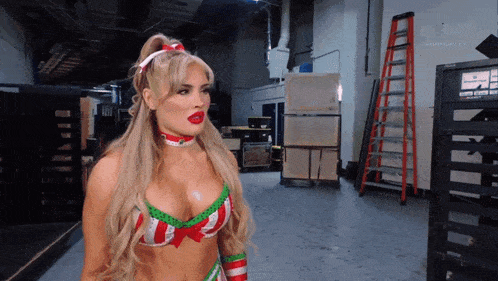 a woman in a christmas outfit is standing in a room with a ladder in the background