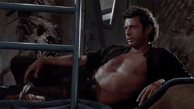 a man without a shirt is sitting on a chair in front of a ladder .