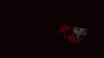 a person 's hand is pointing at a cartoon character with the letter x on his face