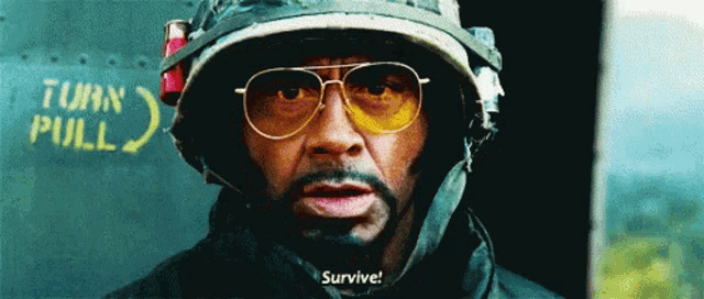 a man wearing a military helmet and sunglasses says survive