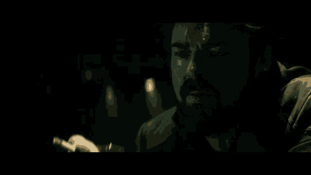 a man with a beard is drinking from a small glass