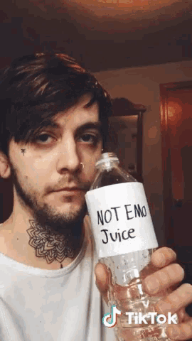 a man holds a bottle of not emo juice