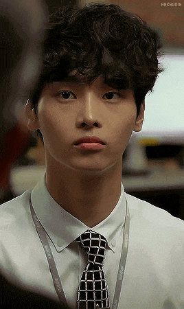 a man with curly hair wearing a white shirt and a black tie