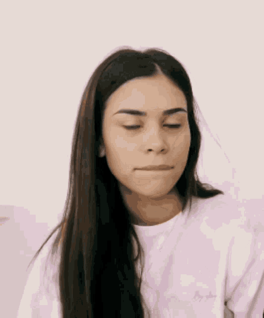 a woman wearing a pink tie dye sweatshirt is making a funny face .