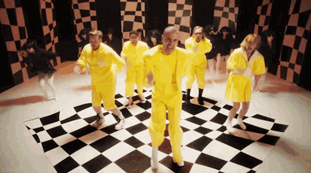 a group of people dancing on a checkered floor
