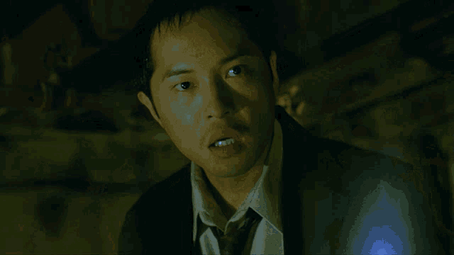 a man in a suit and tie is looking at the camera with a surprised look on his face