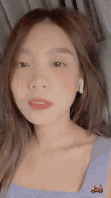 a close up of a woman 's face with a red car on her shoulder