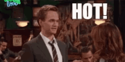 a man in a suit and tie is standing next to a woman in a bar and says `` hot '' .