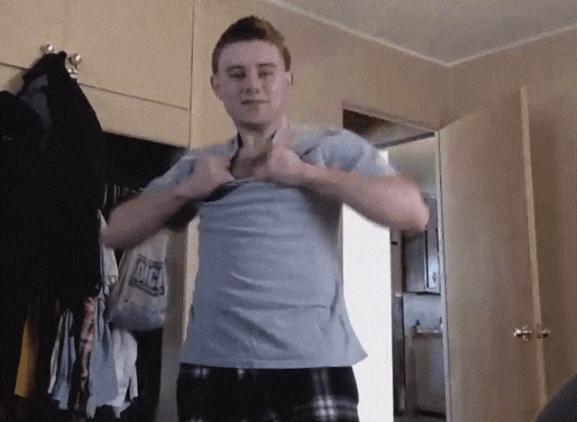 a man wearing a shirt that says dick is standing in a room