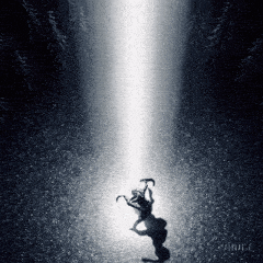 a shadow of a person standing in the dark with a light coming down