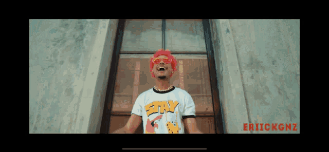 a man with pink hair and a shirt that says stix