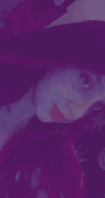 a close up of a woman 's face in a purple light