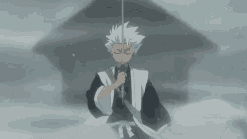 a man in a kimono is holding a sword in his hand .