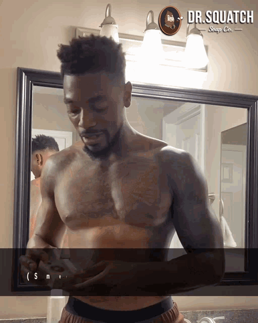 a shirtless man in front of a mirror with dr. squatch soap co.