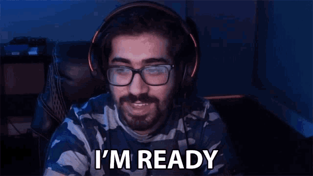 a man wearing headphones and glasses is saying i 'm ready