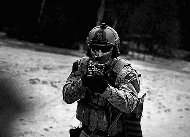 a black and white photo of a soldier in a helmet holding a rifle .
