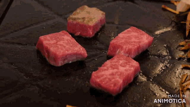 a steak is being cooked on a grill and the words made in animotica are visible