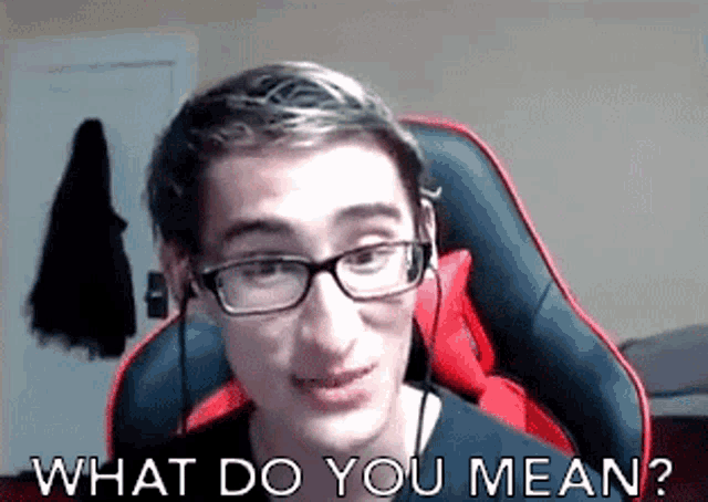 a young man wearing glasses and headphones is sitting in a gaming chair .