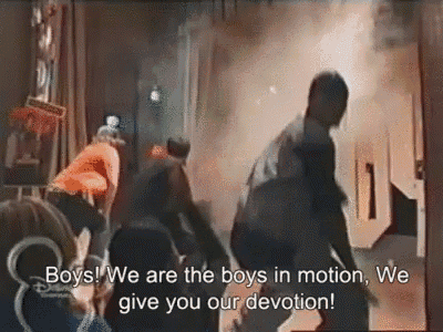 a group of people are standing in front of a smoke filled room with the words boys we are the boys in motion